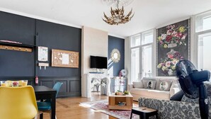 Una sala moderna con comedor, chimenea, ventana grande con vistas y ventilador de techo.