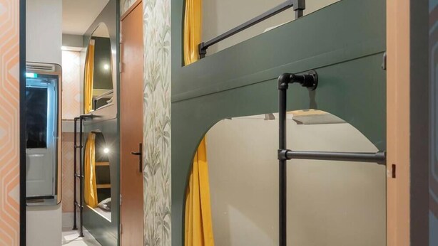 A hotel room with a bunk bed, a wardrobe, and a bathroom with a shower curtain. - Amsterdam Villa | Jacuzzi, Sauna & Cinema (Zwanenburg)
