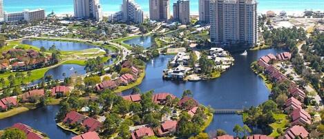 A resort with multiple buildings, a central water body, and surrounding greenery.
