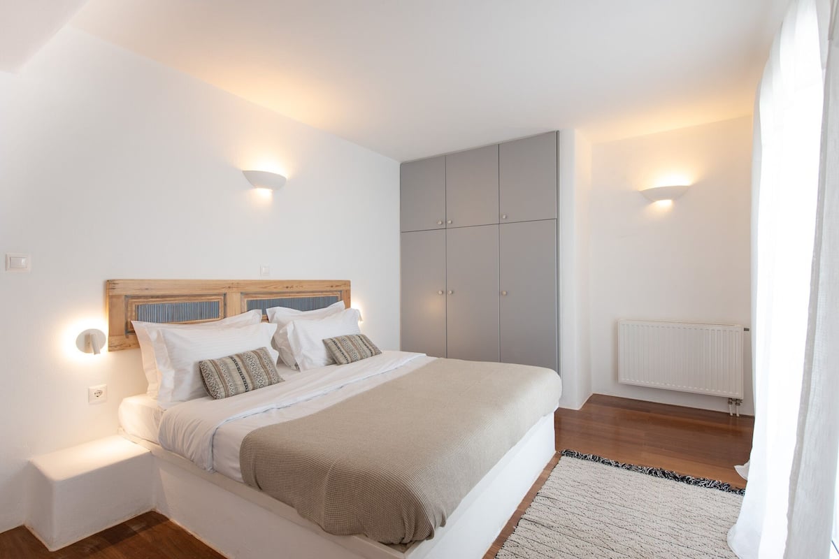 Ein Schlafzimmer mit Bett, Nachttischen, einem Kleiderschrank und einem Heizkörper.