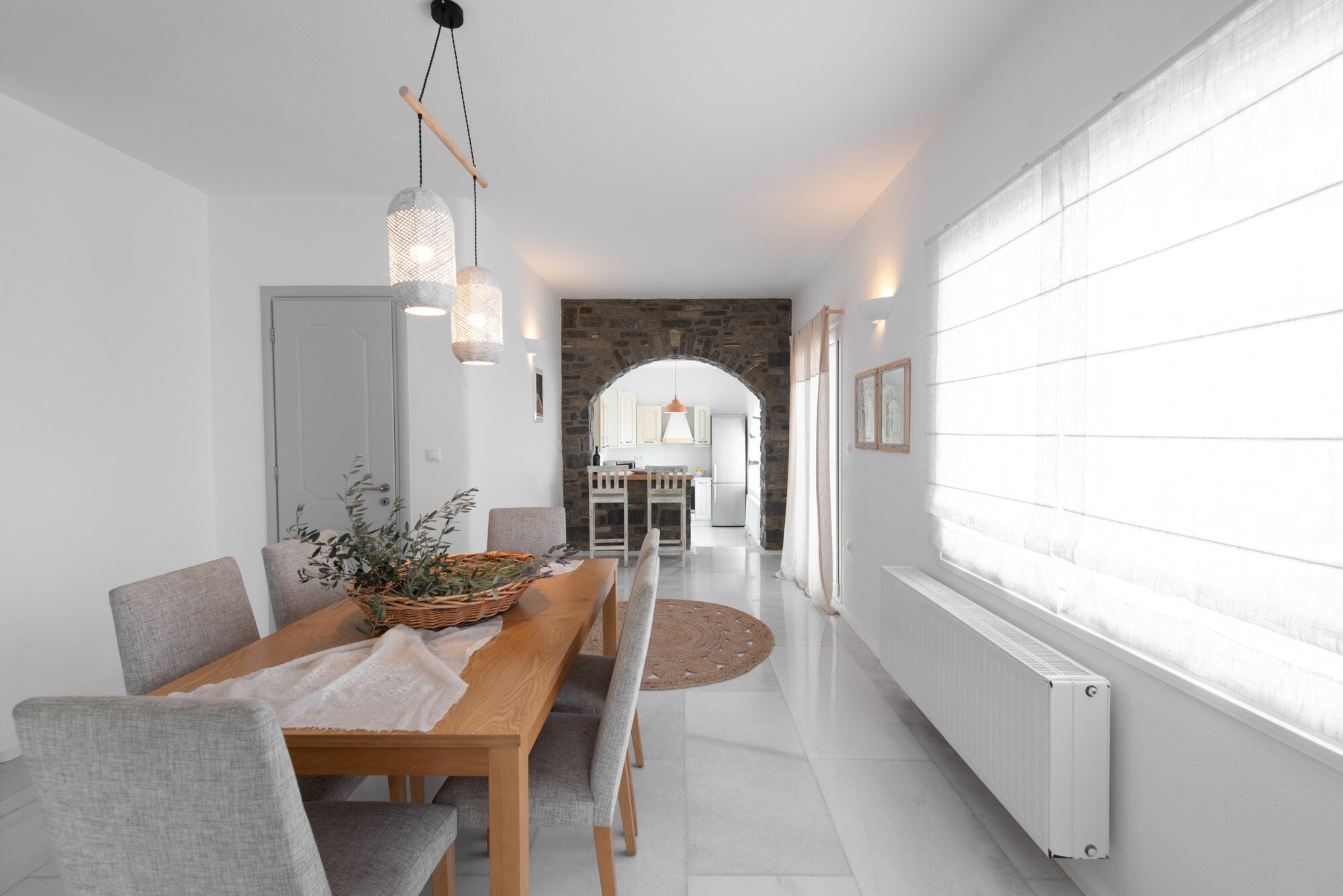 A modern kitchen with a stone archway leading to a dining area.