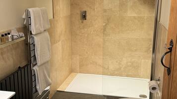 Une salle de bain moderne équipée d’une douche, de toilettes et d’un porte-serviettes.