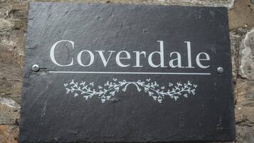 En skiferplade med ordet 'Coverdale' og dekorative blomstermotiver.