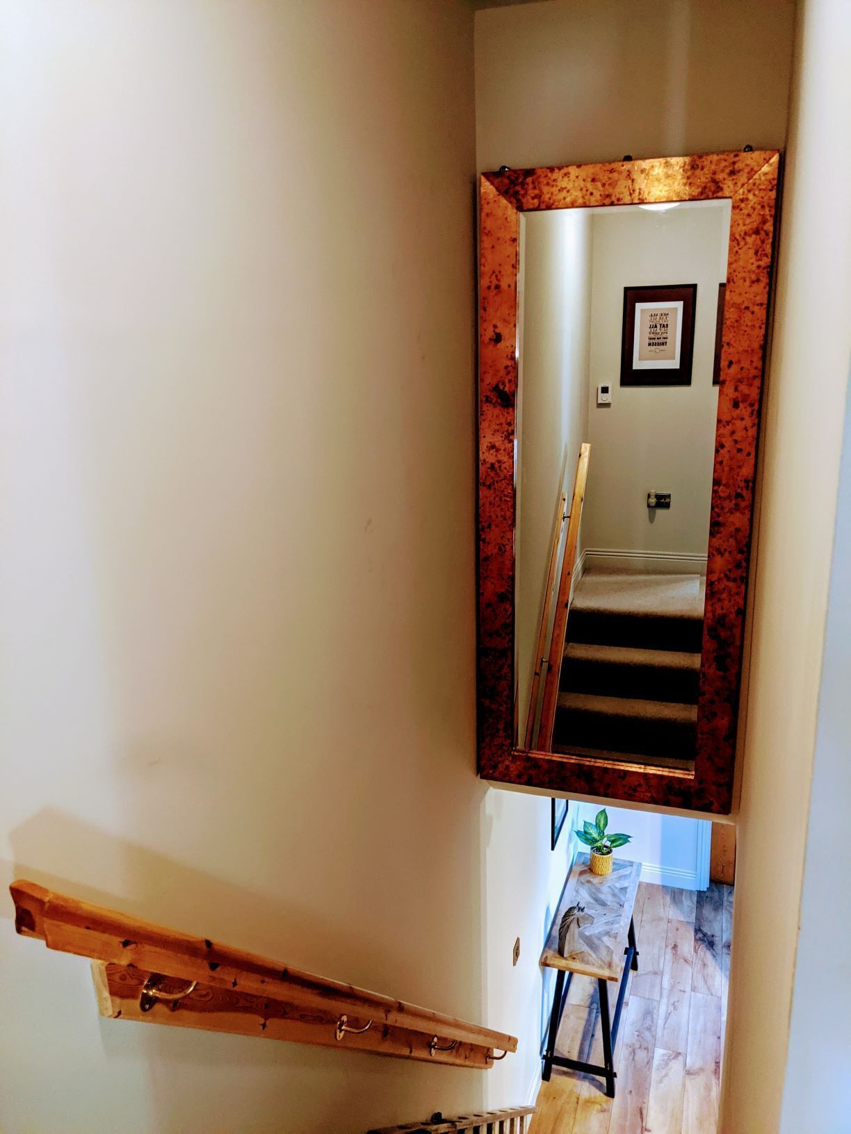 A staircase with a wooden handrail and a metal banister.