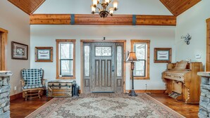 A spacious foyer with a large rug, wooden furniture, and a piano. - Pine Mountain Club Cabin w/ Private Deck & Views! (Pine Mountain Club)