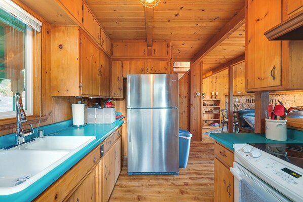 A wooden cabin kitchen with a stainless steel refrigerator, a sink, and a stove. - Cozy Mi-wuk Village Cabin: 18 Mi to Dodge Ridge! (Mi-Wuk Village)