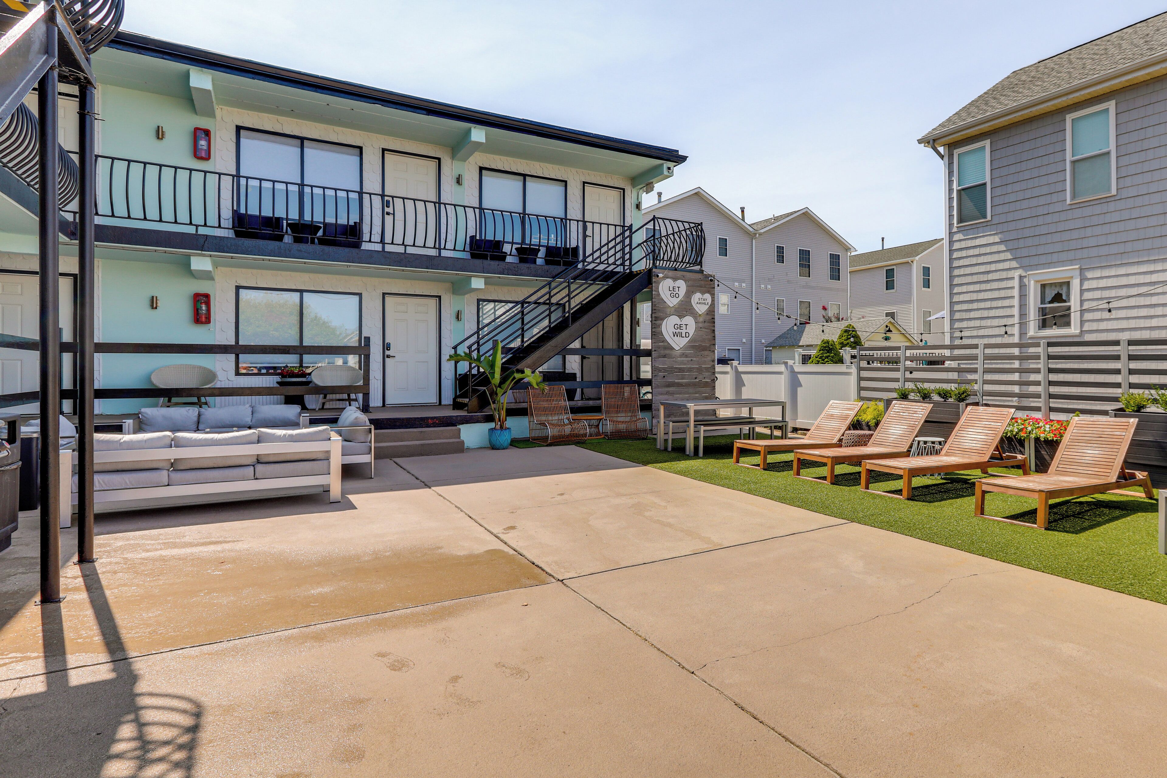 A two-story building with a balcony, outdoor seating area, and a fire extinguisher.
