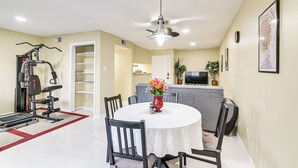 A dining area with a round table, chairs, a ceiling fan, and exercise equipment in the background. - Houston Condo w/ Pool Access ~ 1 Mi to NRG Stadium (Houston)