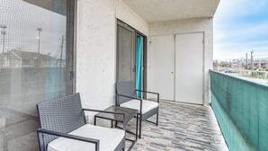 A balcony with two chairs and a table, a door, and a view of the cityscape. - Houston Condo w/ Pool Access ~ 1 Mi to NRG Stadium (Houston)