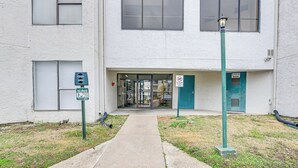 A building entrance with a pathway leading to the door, a no parking sign, and a green sign indicating a room for the disabled. - Houston Condo w/ Pool Access ~ 1 Mi to NRG Stadium (Houston)