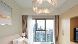A hotel room with a large bed, a view of the cityscape, a chandelier, and a flat-screen TV. - Burj Royale Luxury 1bedroom Balcony City View (Dubai)