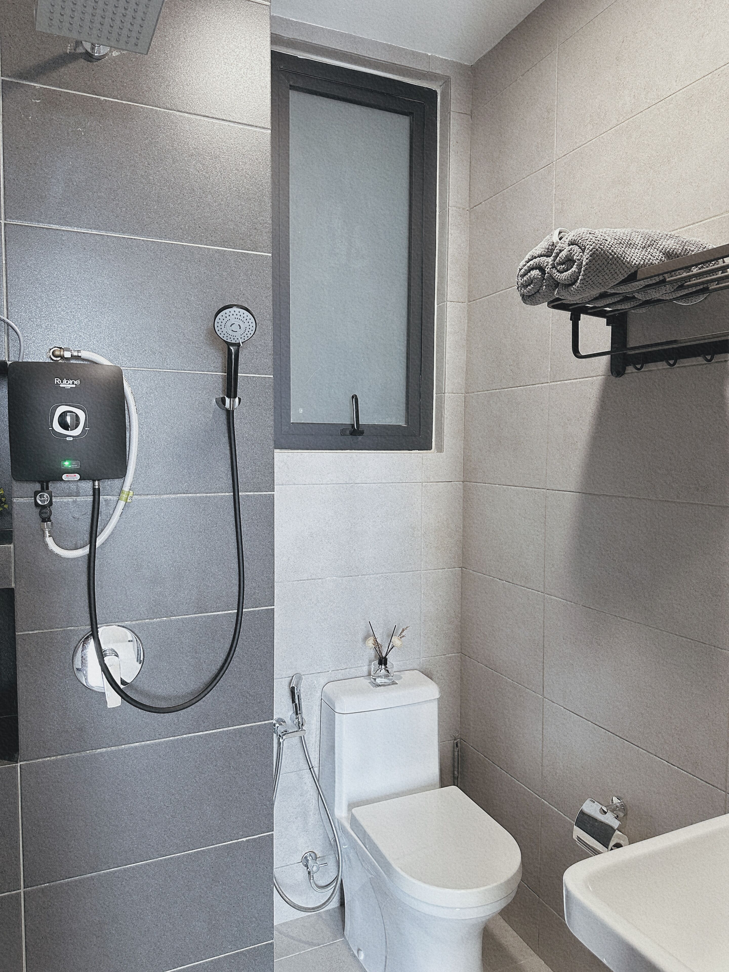 A bathroom with a shower, toilet, and sink.