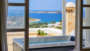 A room with a view of the sea, a stone tower, and a cactus plant. - Anthemion Paros Villas & Suites (Paros)