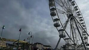 Et stort pariserhjul med flere gondoler mod en skyet himmel.