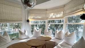 A room with a large window, white bedding, and a disco ball. - Renovated Family Home 270 Ft to Beach in Seaside, FL + 2 Adult Bikes! (Santa Rosa Beach)
