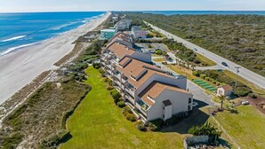 Ein Hotel an der Küste mit mehreren Gebäuden, einem Strand und einer Straße.