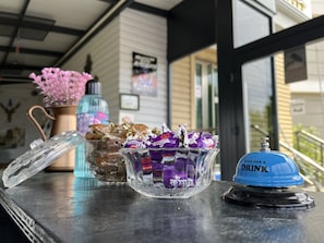 Una mesa con un tarro de caramelos, un dispensador de bebidas azul y una botella de agua.