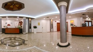 A spacious lobby with a reception desk, multiple columns, and a decorative ceiling. - San Raffaele Hotel Restaurant & Resort (Castelluccio Superiore)
