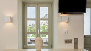 Una cocina con televisor integrado, un florero sobre la encimera y una silla.