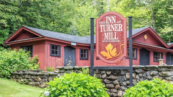 Um edifício vermelho com uma placa que diz 'The Inn at Turner Mill, Notch Brook'.