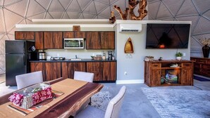 Una cocina moderna con armarios de madera, un refrigerador negro y un microondas integrado.