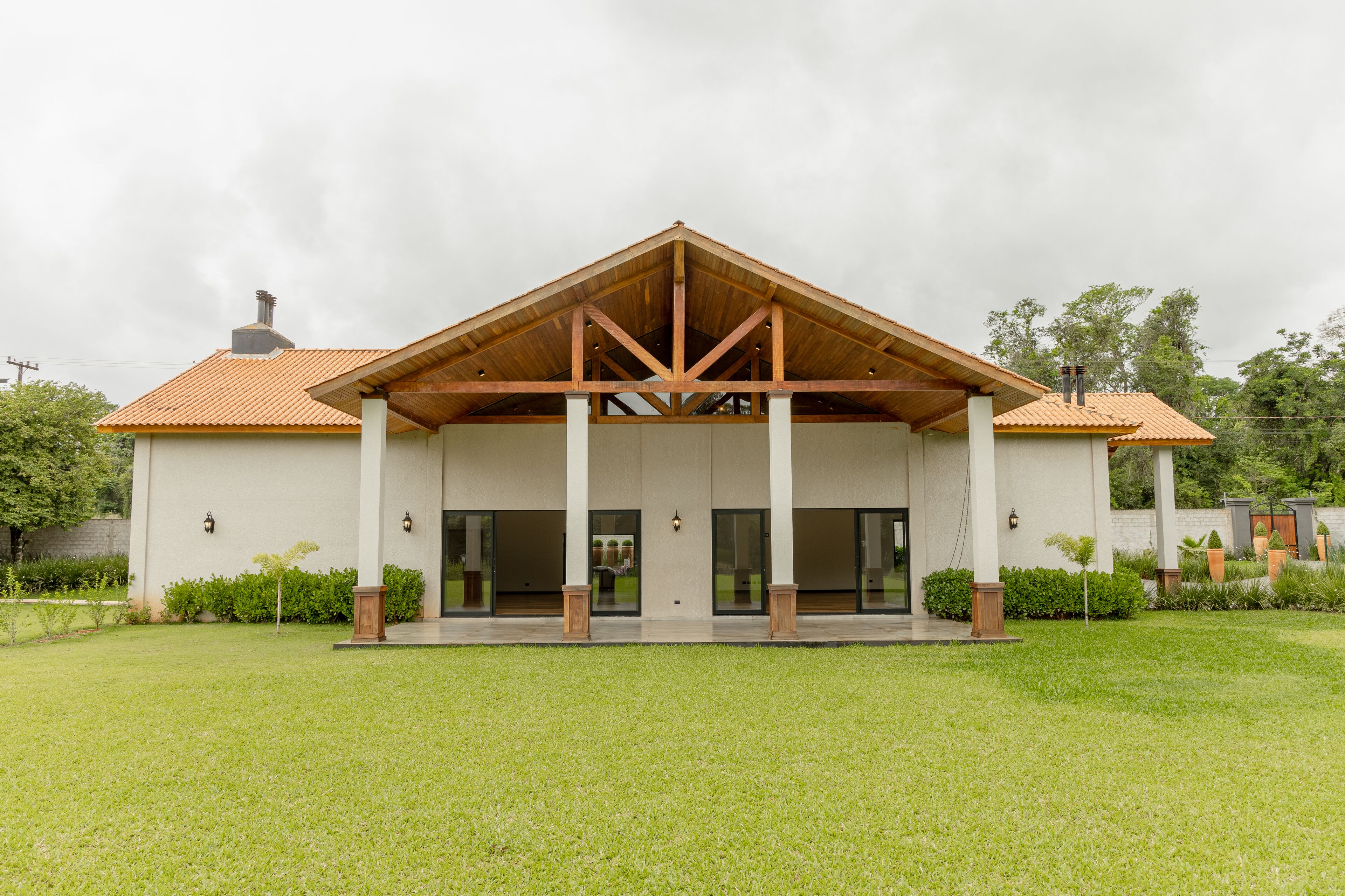 A modern building with a covered entrance, large windows, and a well-maintained lawn.