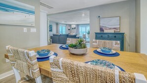 A dining area with a wooden table, woven chairs, and blue and white patterned bowls.