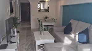 Una sala de estar moderna con un sofá, una mesa de centro y un comedor con sillas y una mesa.