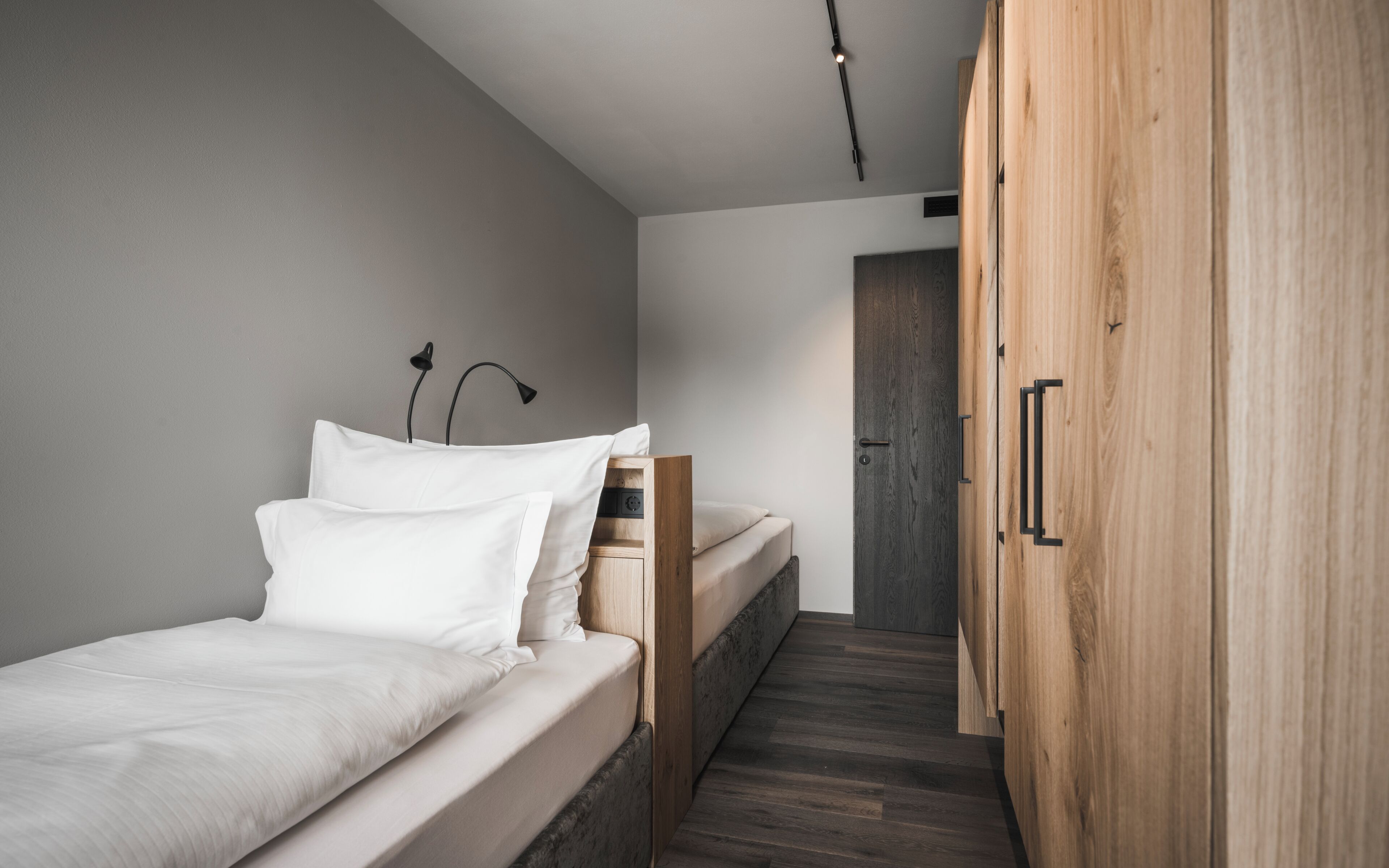 A bedroom with a bed, bedside table, and a wardrobe.