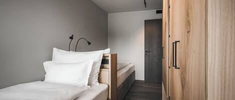 A bedroom with a bed, bedside table, and a wardrobe.