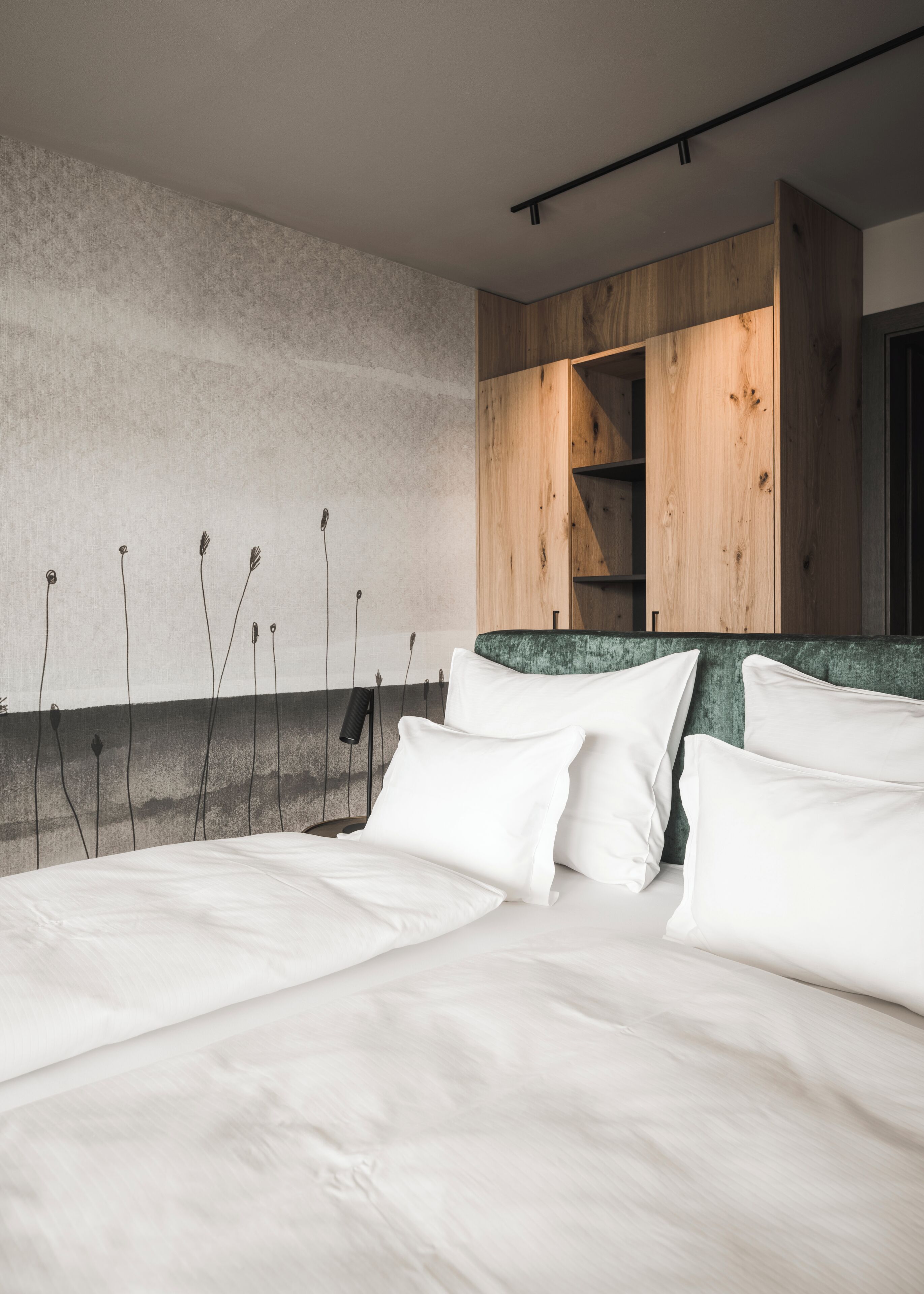 Quarto moderno com cama grande, cabeceira de madeira e parede texturizada.