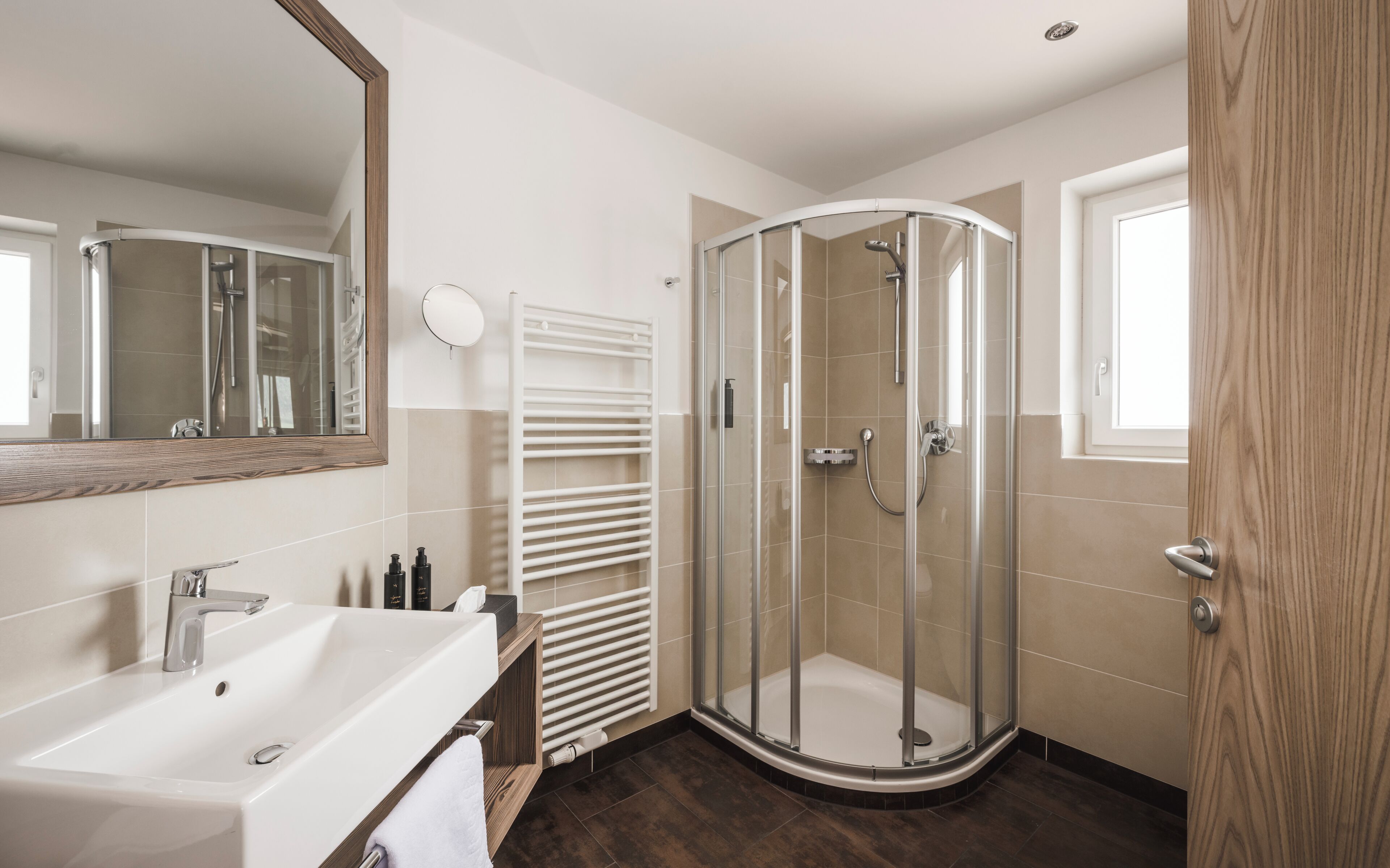 A modern bathroom with a shower, a sink, and a mirror.