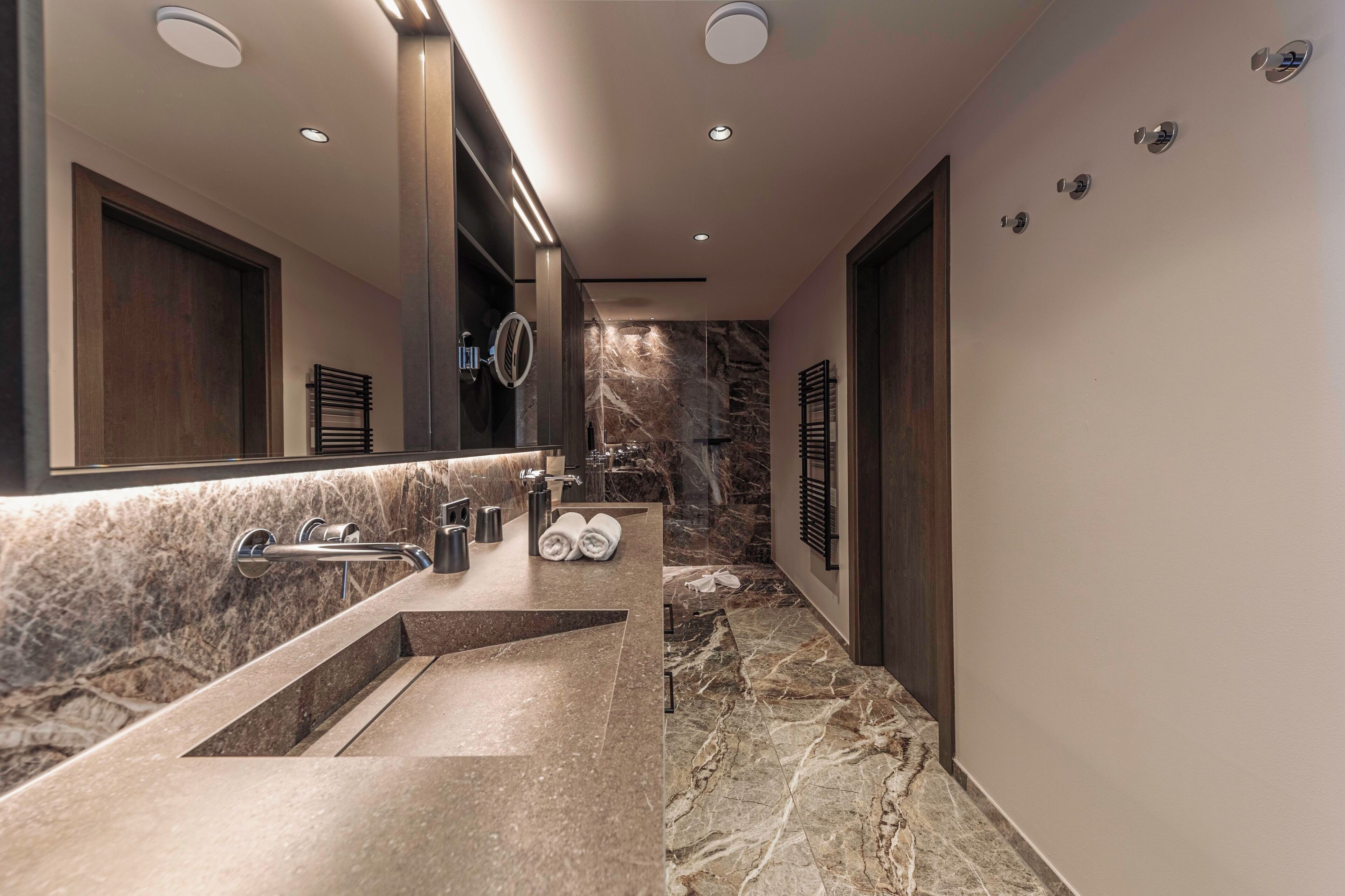 Un baño moderno con un lavamanos grande, un espejo y una zona de ducha.