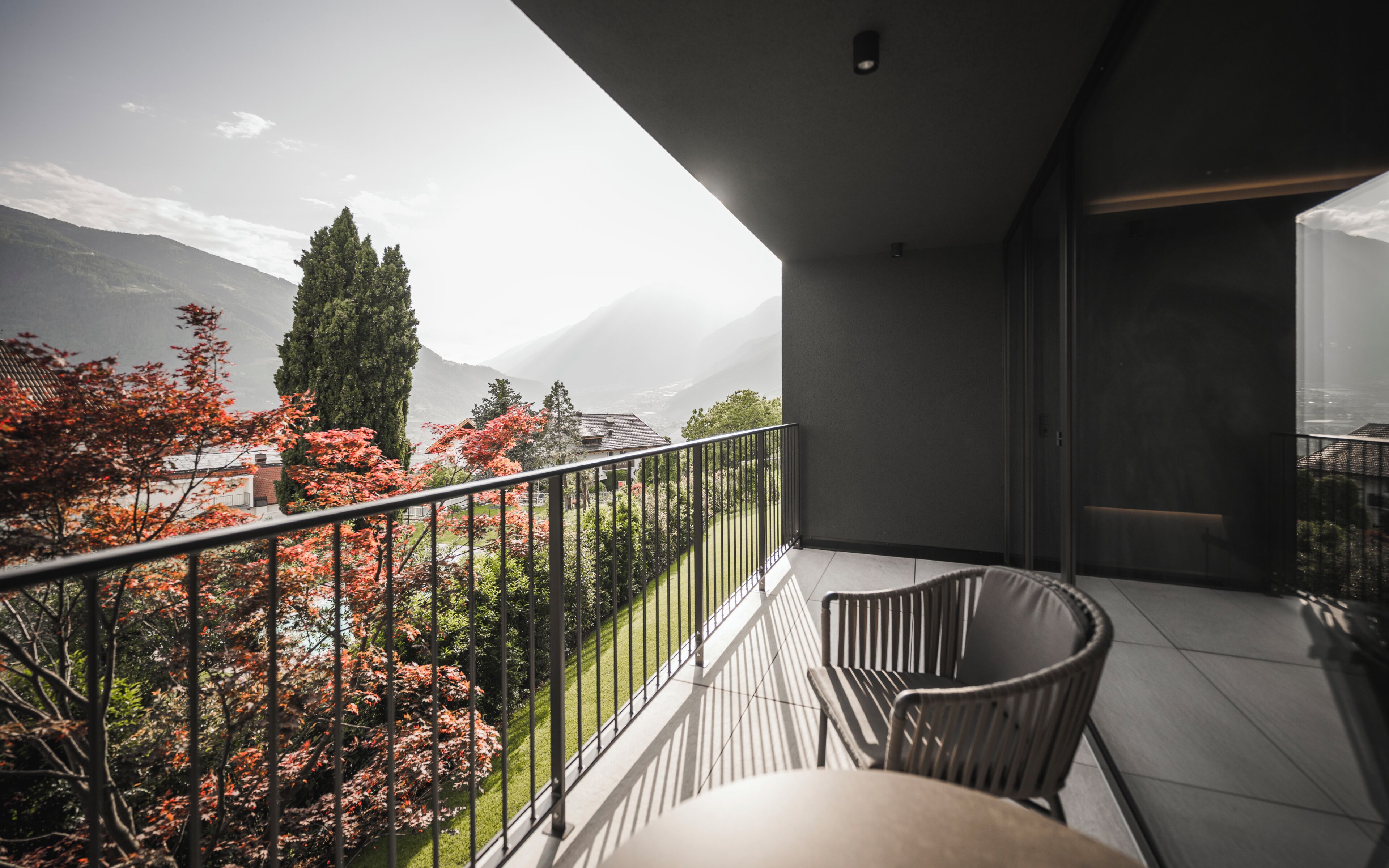 Een balkon met uitzicht op bergen en herfstkleuren.