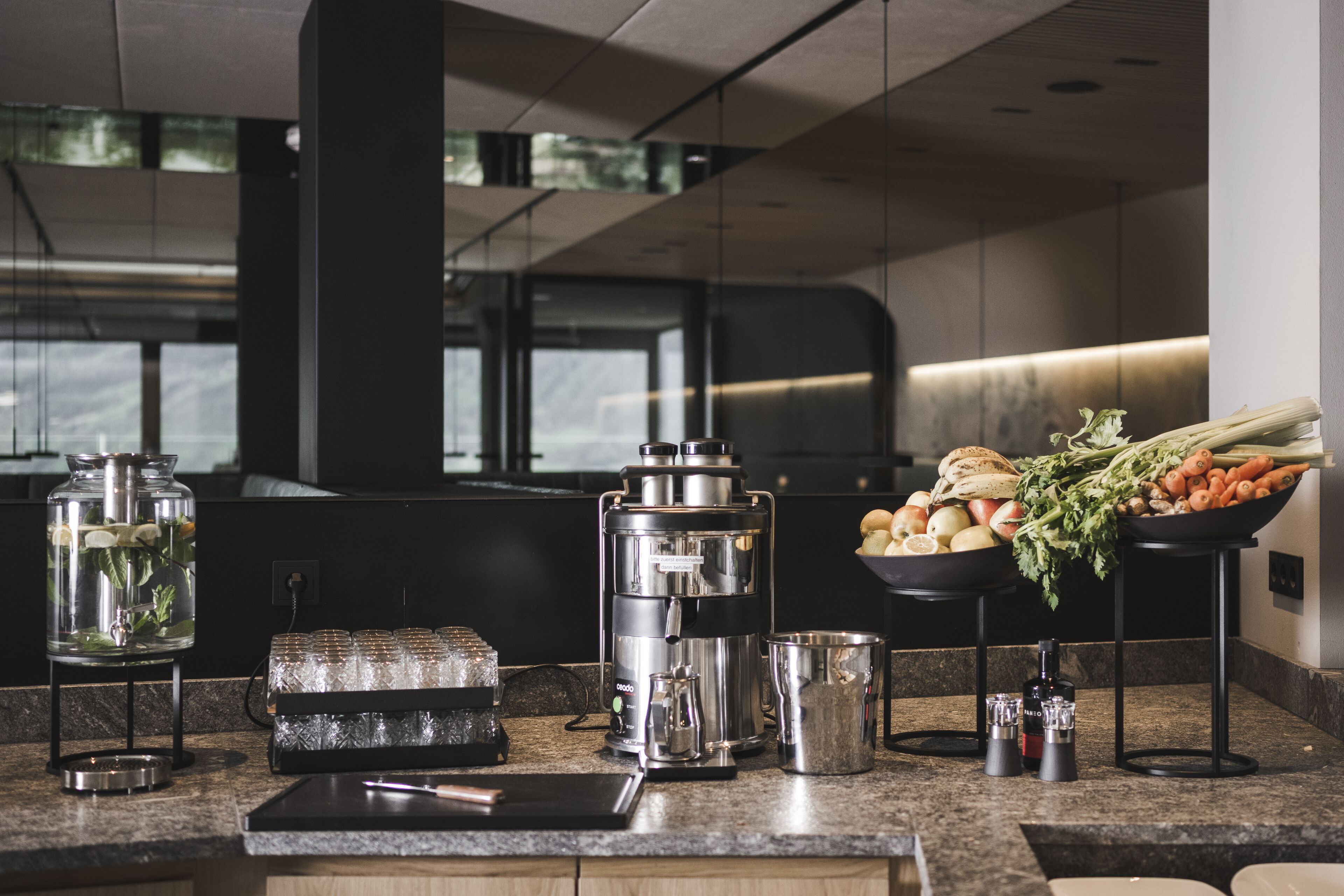 Een moderne keuken met een koffieapparaat, een waterdispenser en verse groenten op het aanrecht.