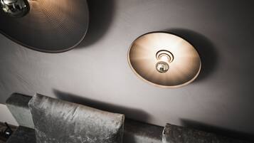 A ceiling with two light fixtures and a marble wall.