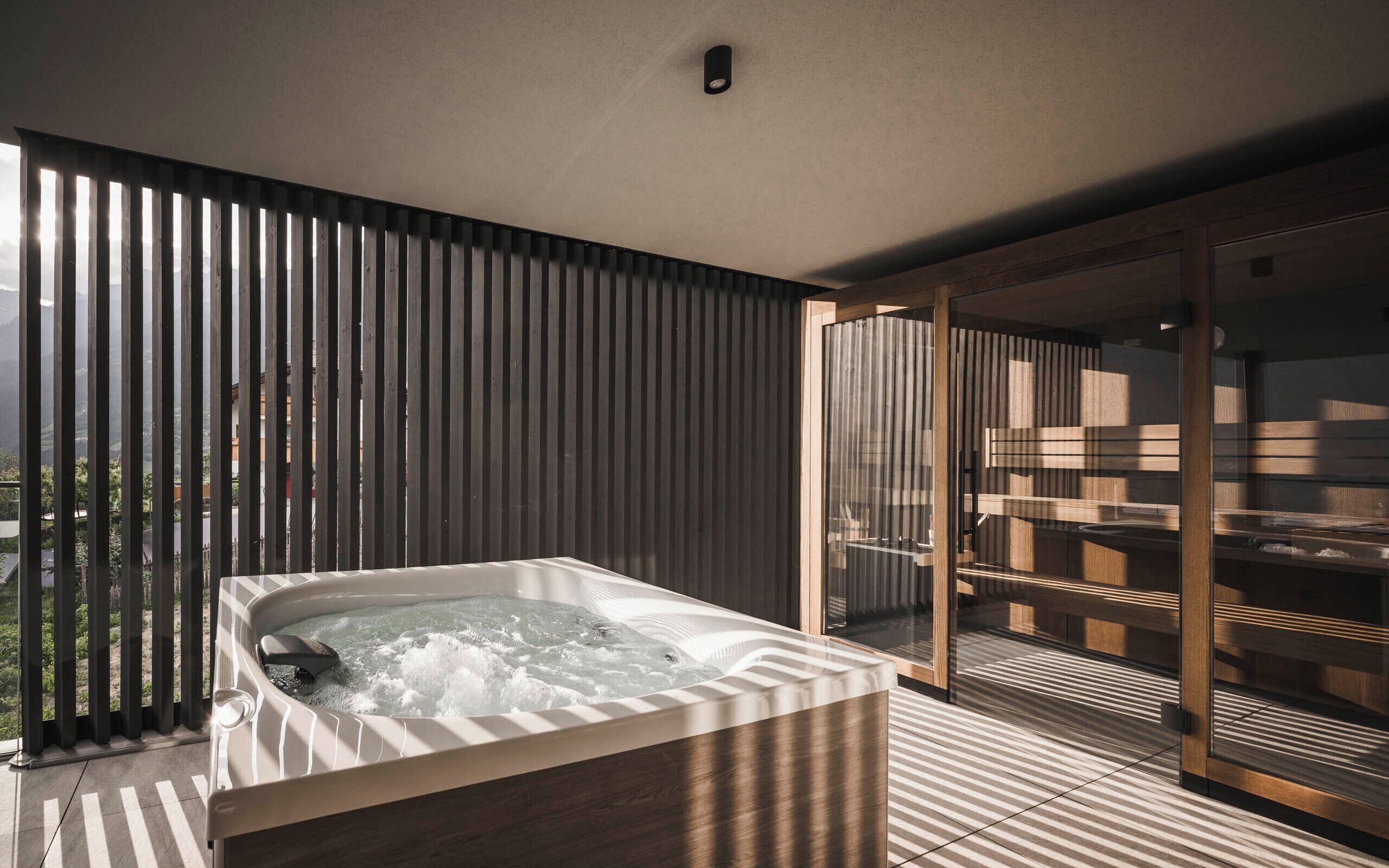 Un baño moderno con una bañera independiente, cabina de ducha con paredes de vidrio y vistas al exterior.
