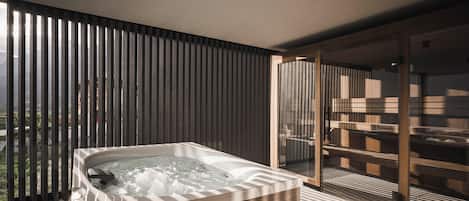 A modern bathroom with a freestanding bathtub, a glass shower enclosure, and a view of the outdoors.