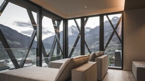 Una habitación moderna con amplios ventanales que ofrecen vistas a la montaña.