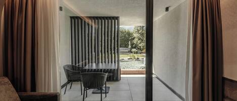 Un interior moderno con una puerta de cristal corredera que da a un patio al aire libre.
