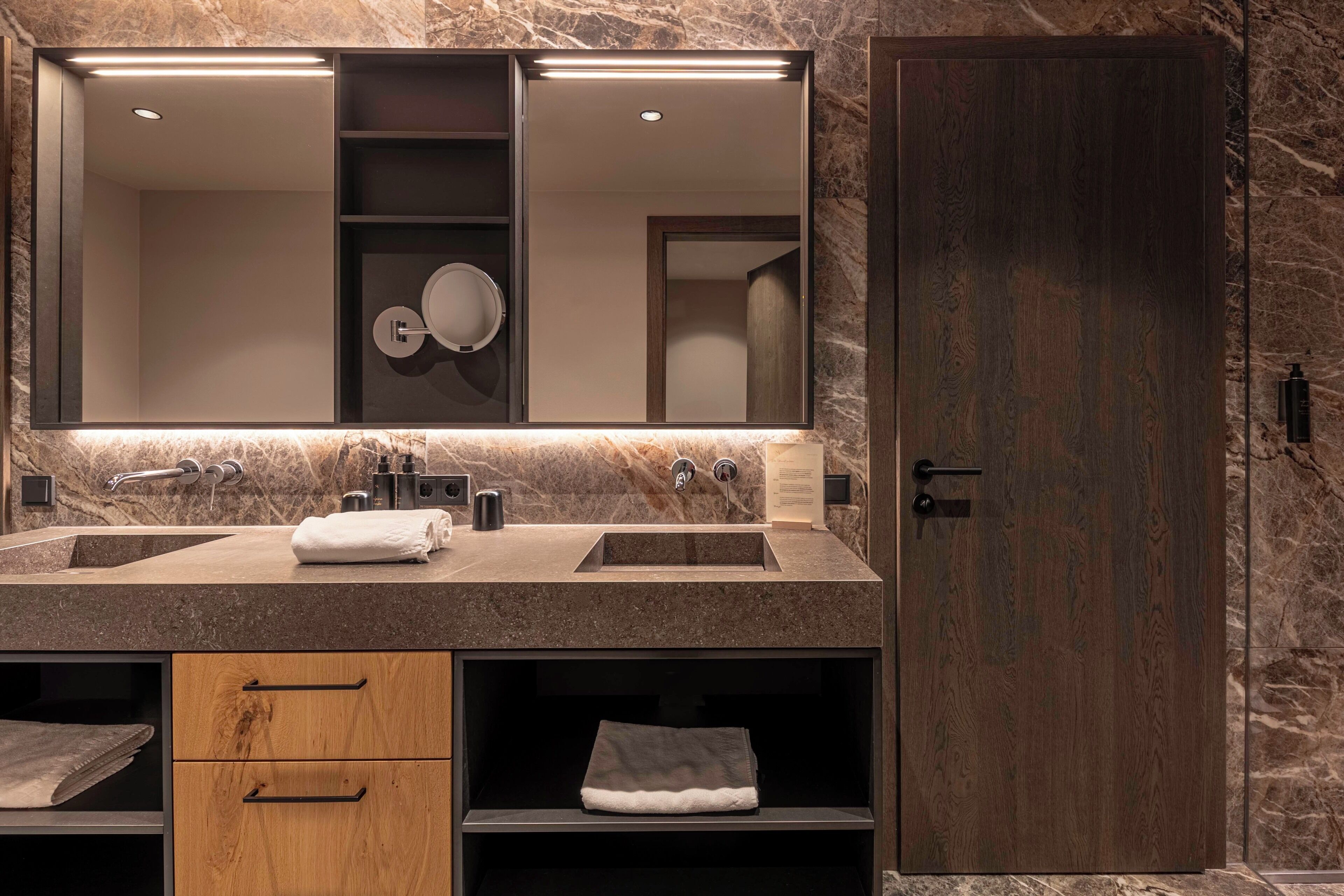 Un baño moderno con dos lavamanos, un espejo y un mueble de madera.