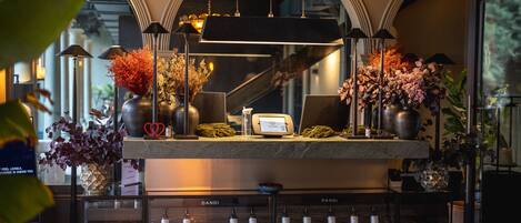 A reception area with a marble counter, potted plants, and a Dandi sign.