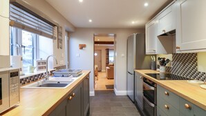 Una cucina moderna con isola centrale, elettrodomestici in acciaio inossidabile e vista sull'area pranzo.