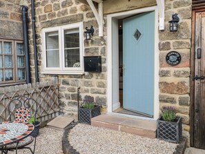 A stone cottage with a blue door, a white window, and a sign reading "Clematis Cottage". - Clematis Cottage (Belper)