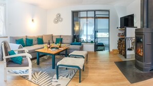 A modern living room with a sofa, coffee table, and a fireplace. - Maison Individuelle, Terrasse et Jardin Clos (Cauterets)