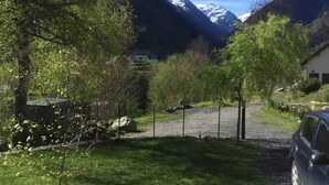 A residential area with a house, a car, and a mountain backdrop. - Maison Individuelle, Terrasse et Jardin Clos (Cauterets)