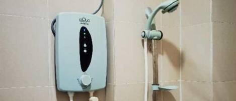 A bathroom with a wall-mounted shower unit, including a control panel and a handheld showerhead.