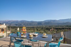 A dining table set on a balcony with a mountain view. - Belle Helens Villa Kefalonia (Kefalonia)