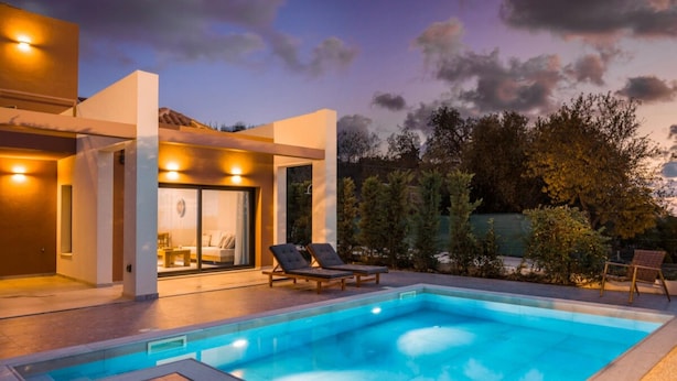 A modern outdoor pool area with lounge chairs, a covered seating area, and a clear view of the pool. - Nirvana - Unalome Villas (Kefalonia)