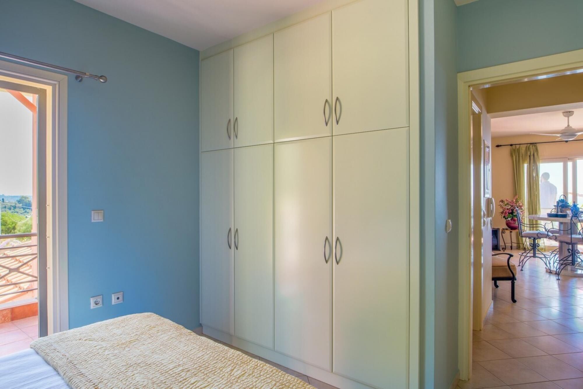 Un dormitorio con cama, armario y vistas al exterior.